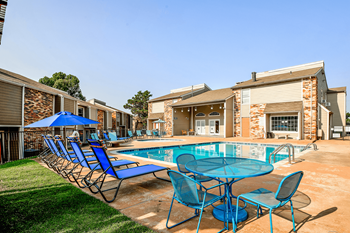 Our apartments have a resort style pool with blue chairs and tables